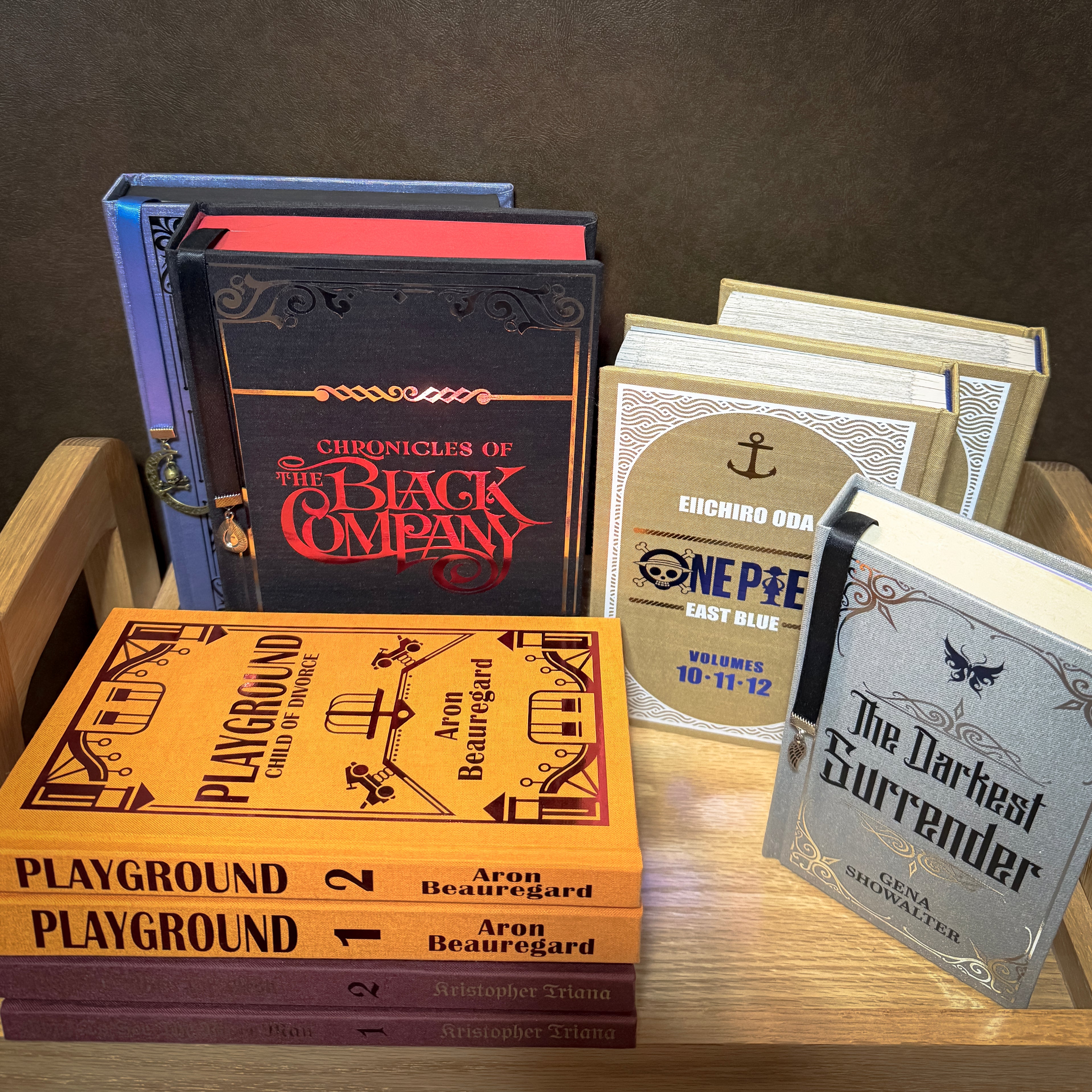 Collection of books on a wooden surface with a dark brown background